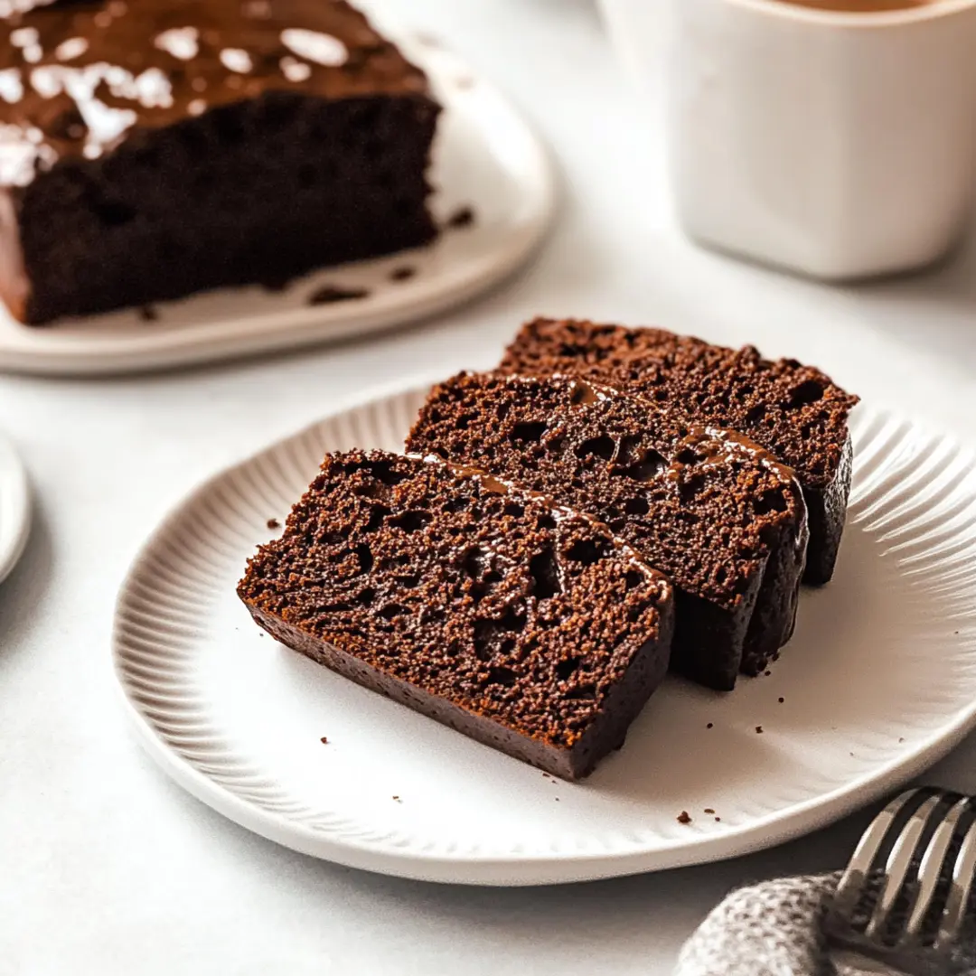 Close-up of sliced chocolate bread served on a white plate, showcasing its rich and moist texture.