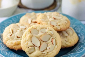 Almond cookies topped with sliced almonds on a blue plate.