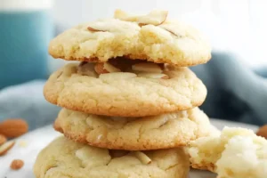 Stack of soft almond cookies with one cookie bitten to show texture.