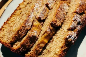 Close-up of sliced cinnamon banana bread with a dusting of sugar.