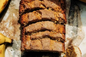 Freshly baked cinnamon banana bread with a cinnamon sugar crust and ripe bananas.