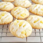 Close-up of pineapple cookies with icing drizzle and pineapple chunks on top.