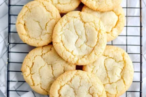 A stack of golden vanilla cookies cooling on a wire rack.