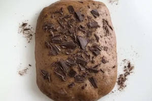 Chocolate sourdough bread dough topped with chopped dark chocolate.